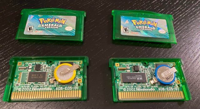 Two Pokemon Emerald cartridges opened side by side showing different circuit boards — a genuine board versus a counterfeit