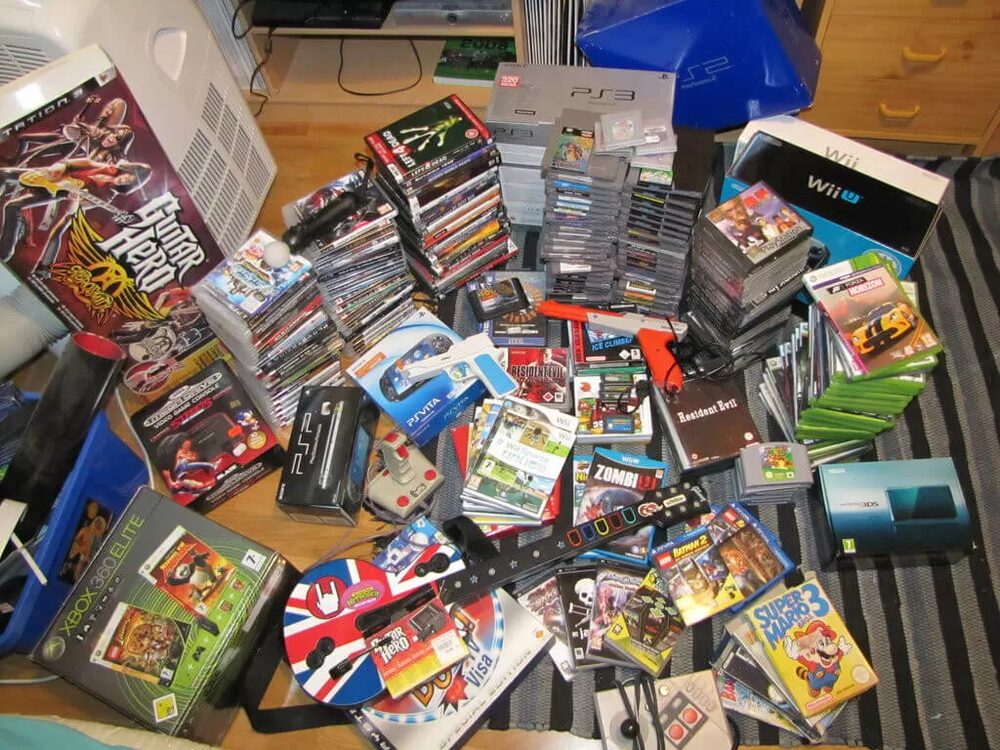 A large haul of video games and consoles laid out — a collection being prepared to sell