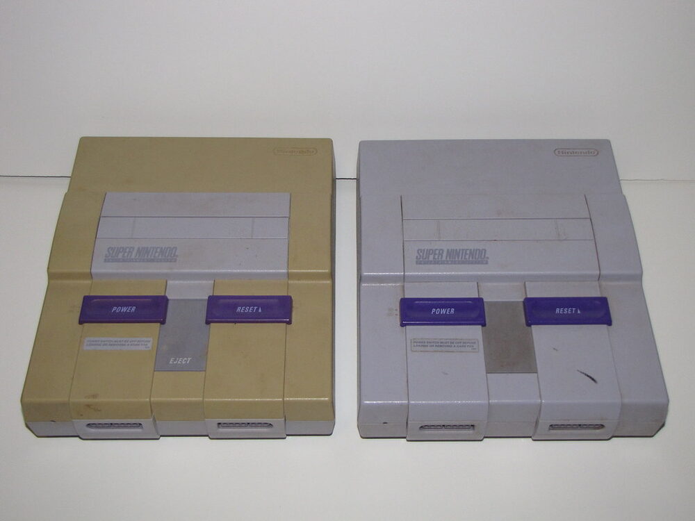 Two Super Nintendo consoles side by side — one badly yellowed by UV light exposure, one kept out of sunlight